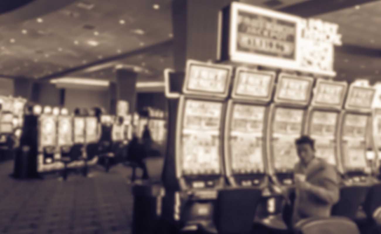 sepia blurred image of slot machines in vintage casino