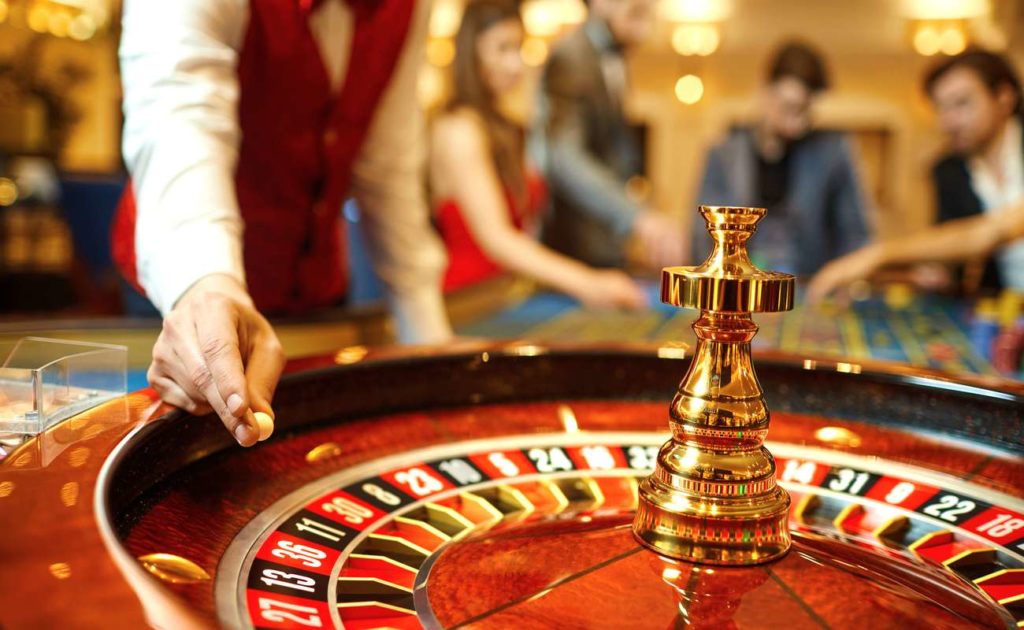 The croupier holds a roulette ball in a casino in his hand