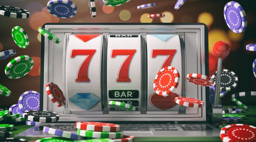 concept of playing slots and poker online, poker chips surrounding laptop