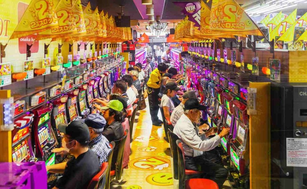 Pachinko game center with rows of people playing