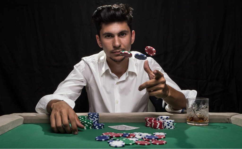 Man sitting at poker table while throwing chips