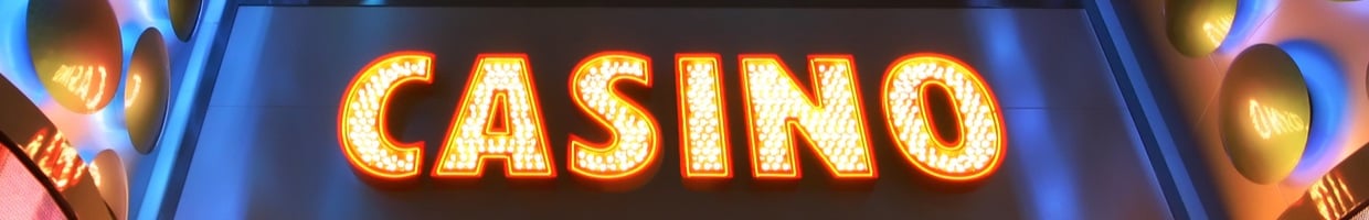 A bright casino sign in lights on the side of a building.