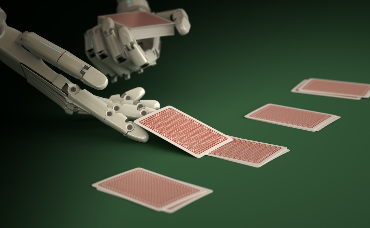 A robot deals out cards onto a green table.