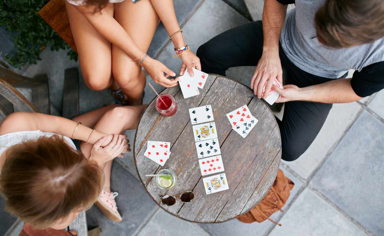 Group of friends playing cards at a table.