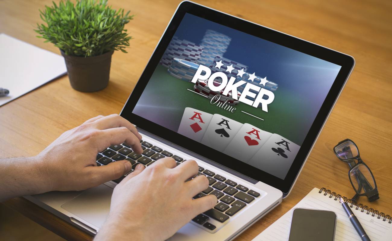 A person plays poker at an online poker site on a laptop.
