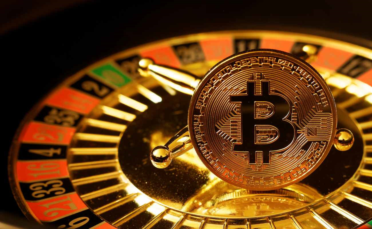A coin with the Bitcoin symbol on it rests on a roulette wheel.