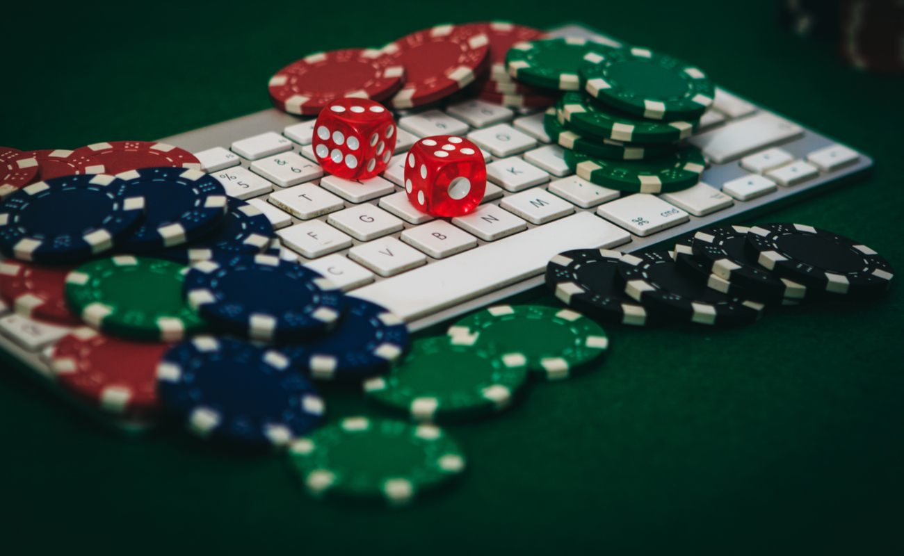 Casino chips and dice sit on top of a keyboard.