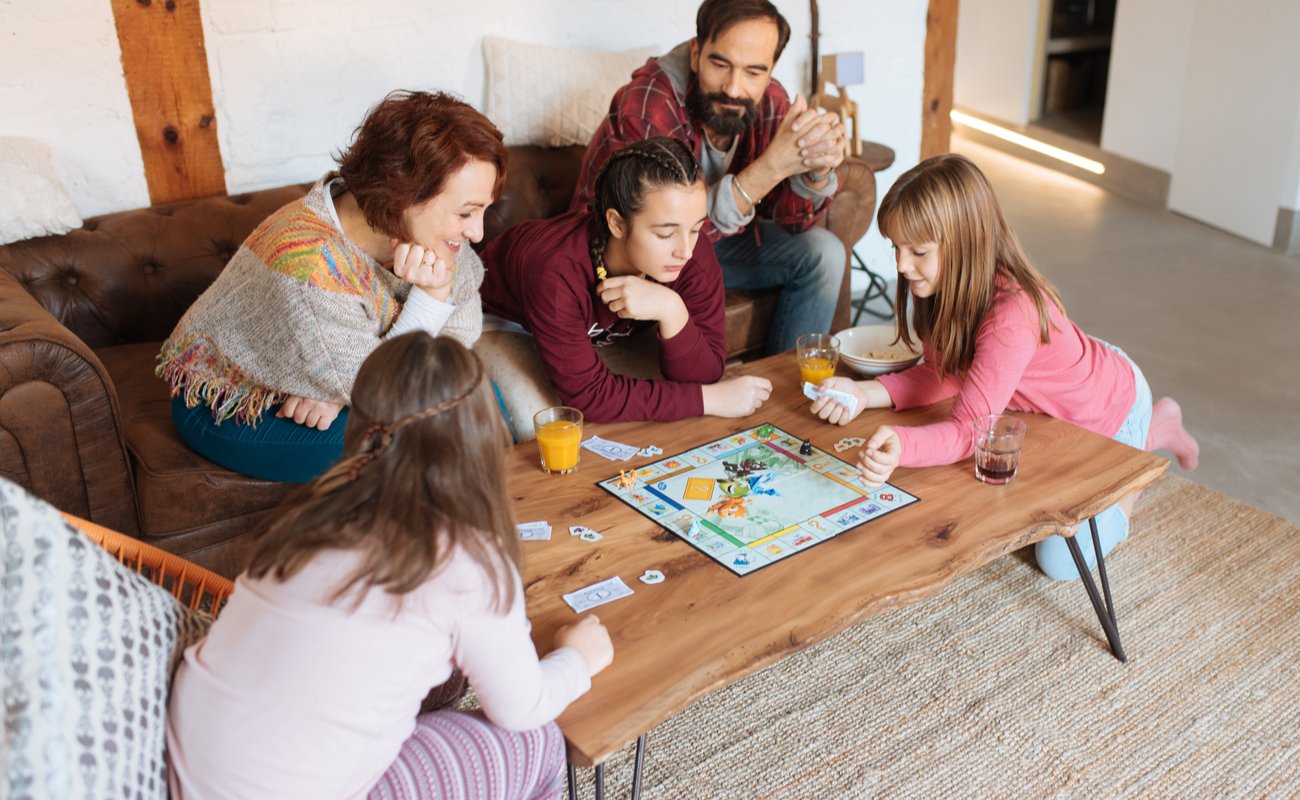 A family playing a board game around a coffee table.