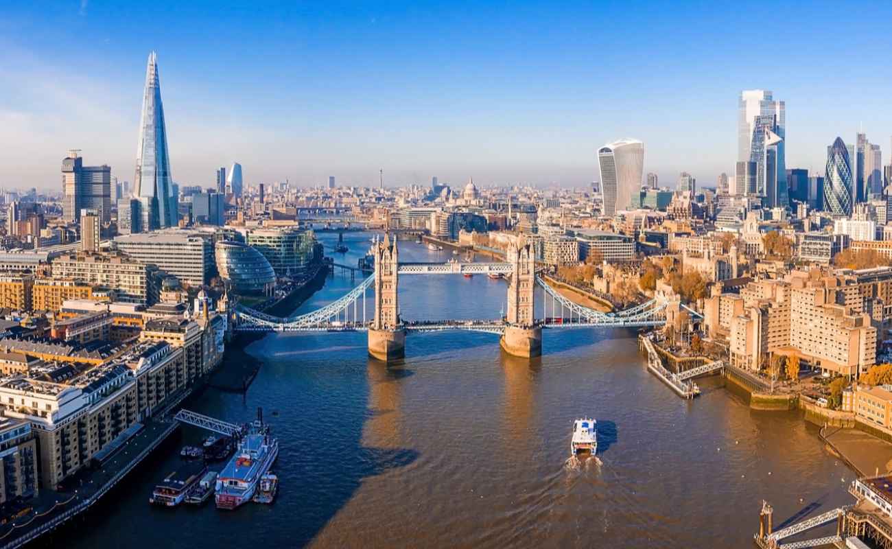 Aerial view of London over the Thames River and Tower Bridge.
