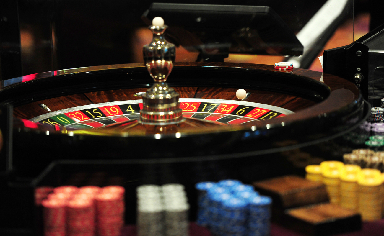 A roulette wheel surrounded by casino chips. 