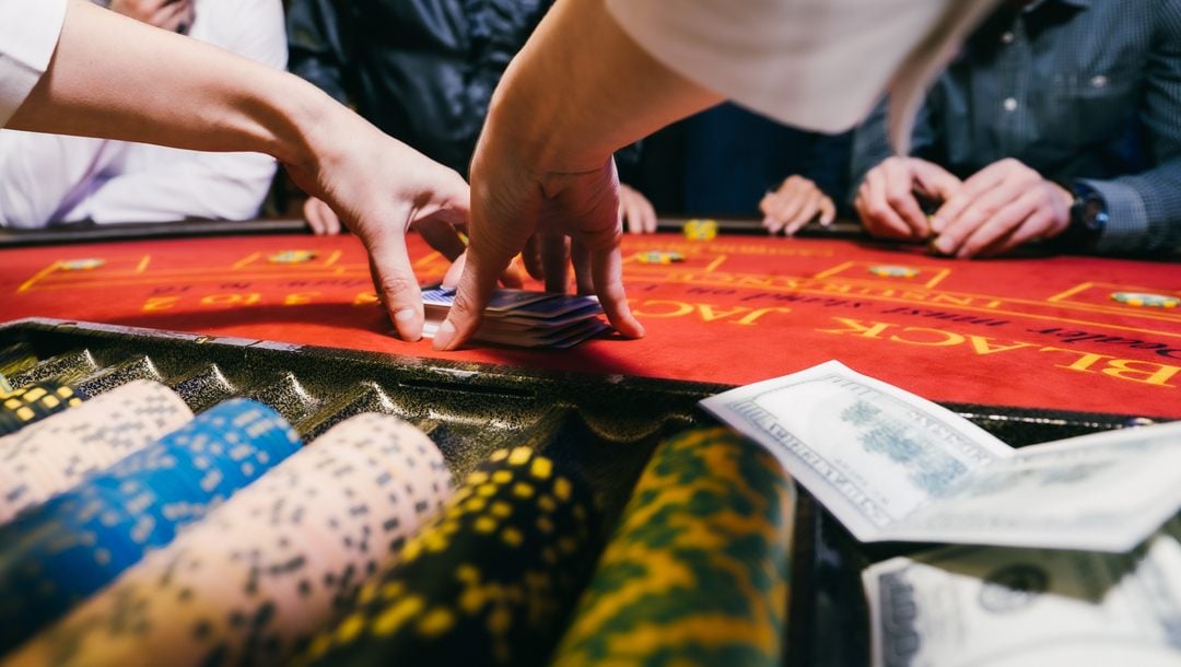 Close up of a croupier handling cards at a blackjack table.