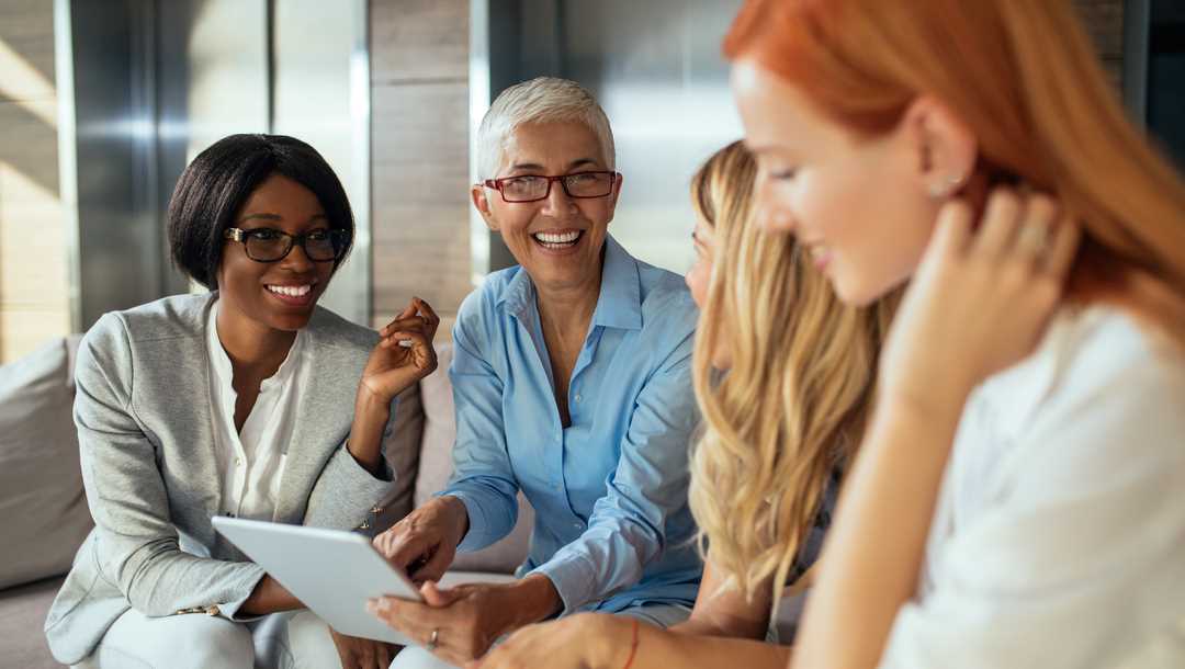 A group of women looking at a tablet.