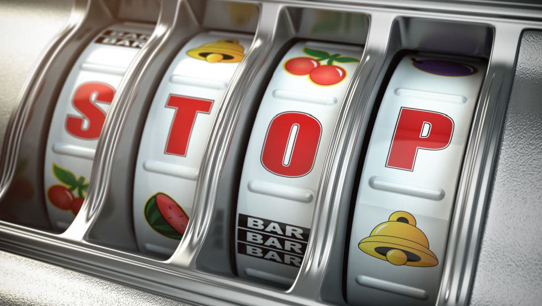 A slot machine with the word “Stop” lining up in the reels.