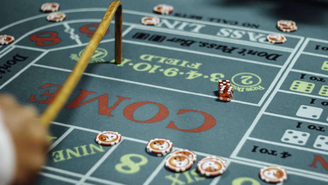 A dealer indicating a spot on the craps table