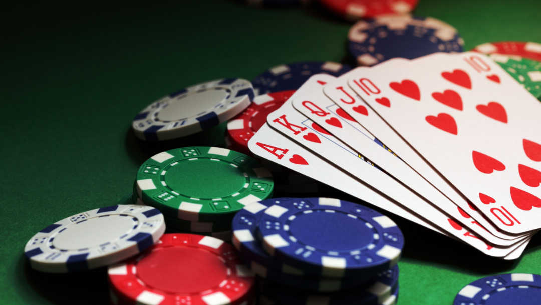 A royal flush hand of cards on top of some poker chips