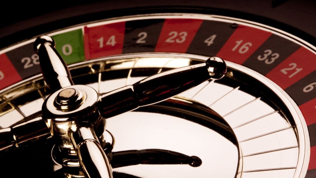 Roulette wheel against black background.