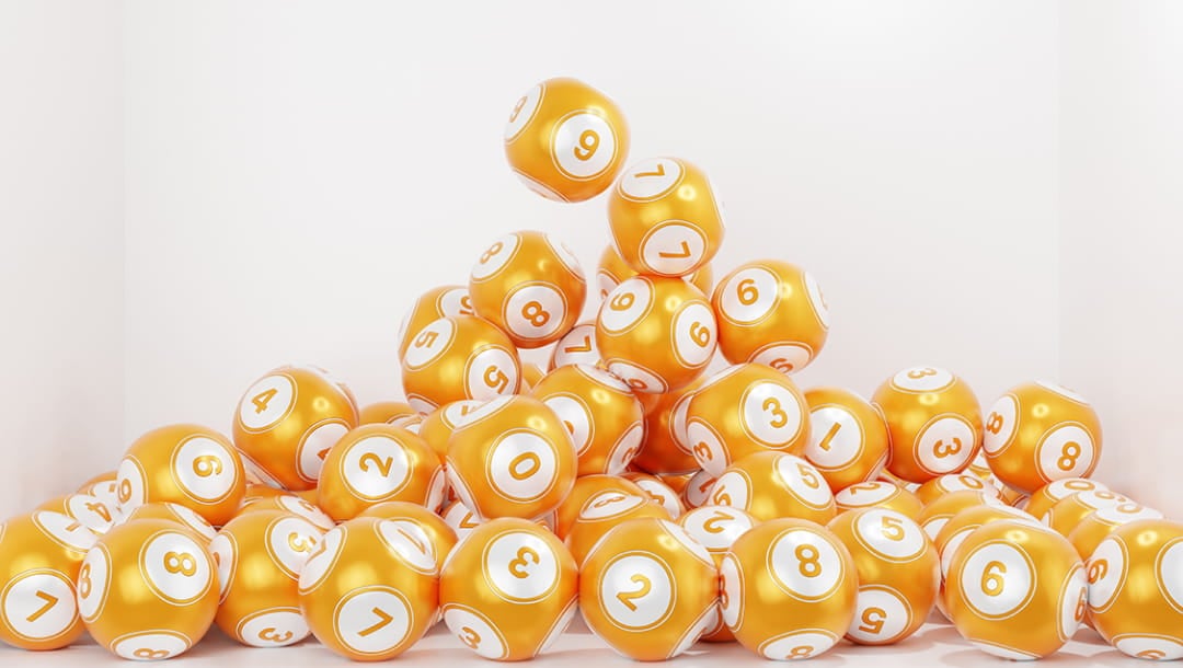 A pile of orange keno balls on the floor with a white background.