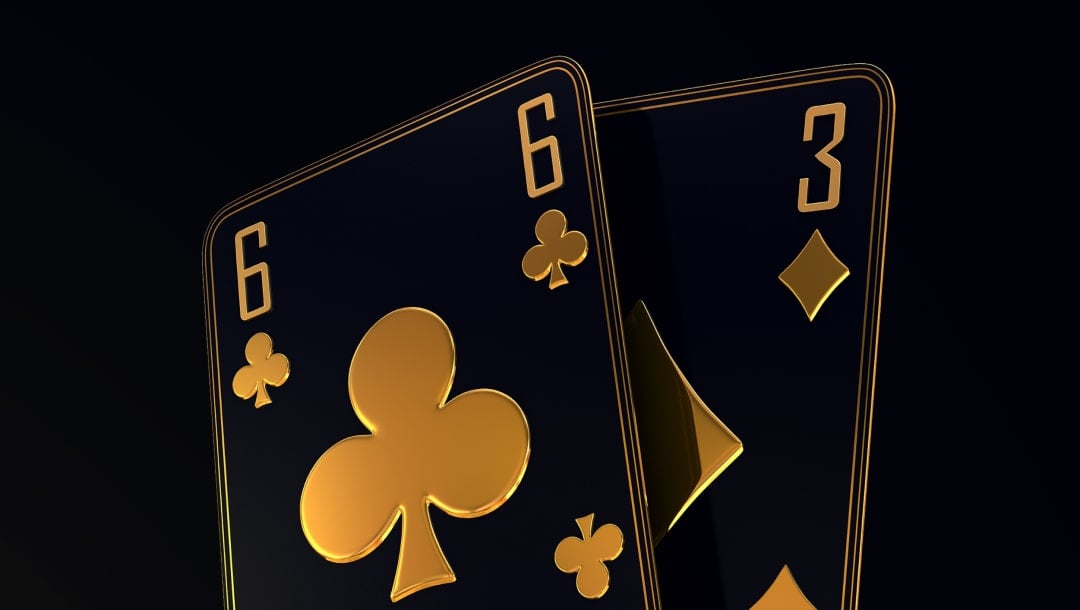 A black and gold six of clubs, and a three of diamonds playing cards, layered on top of each other.